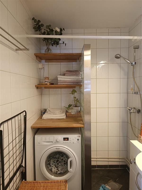 Badet består av et toalett, en dusj, en vaskemaskin.
